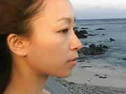 Chica japonesa camina a la orilla del mar